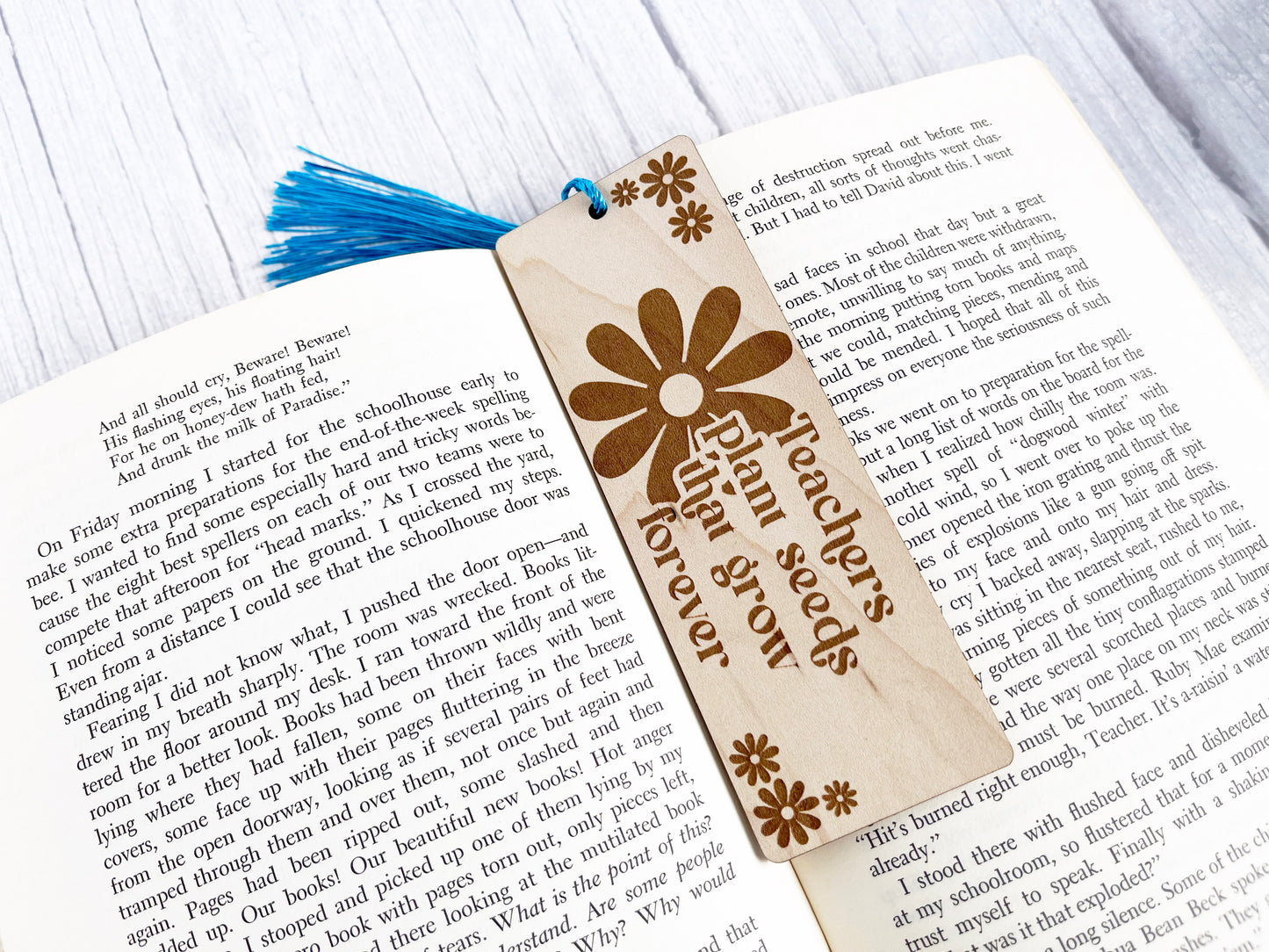 an open book with a wooden bookmark on top of it