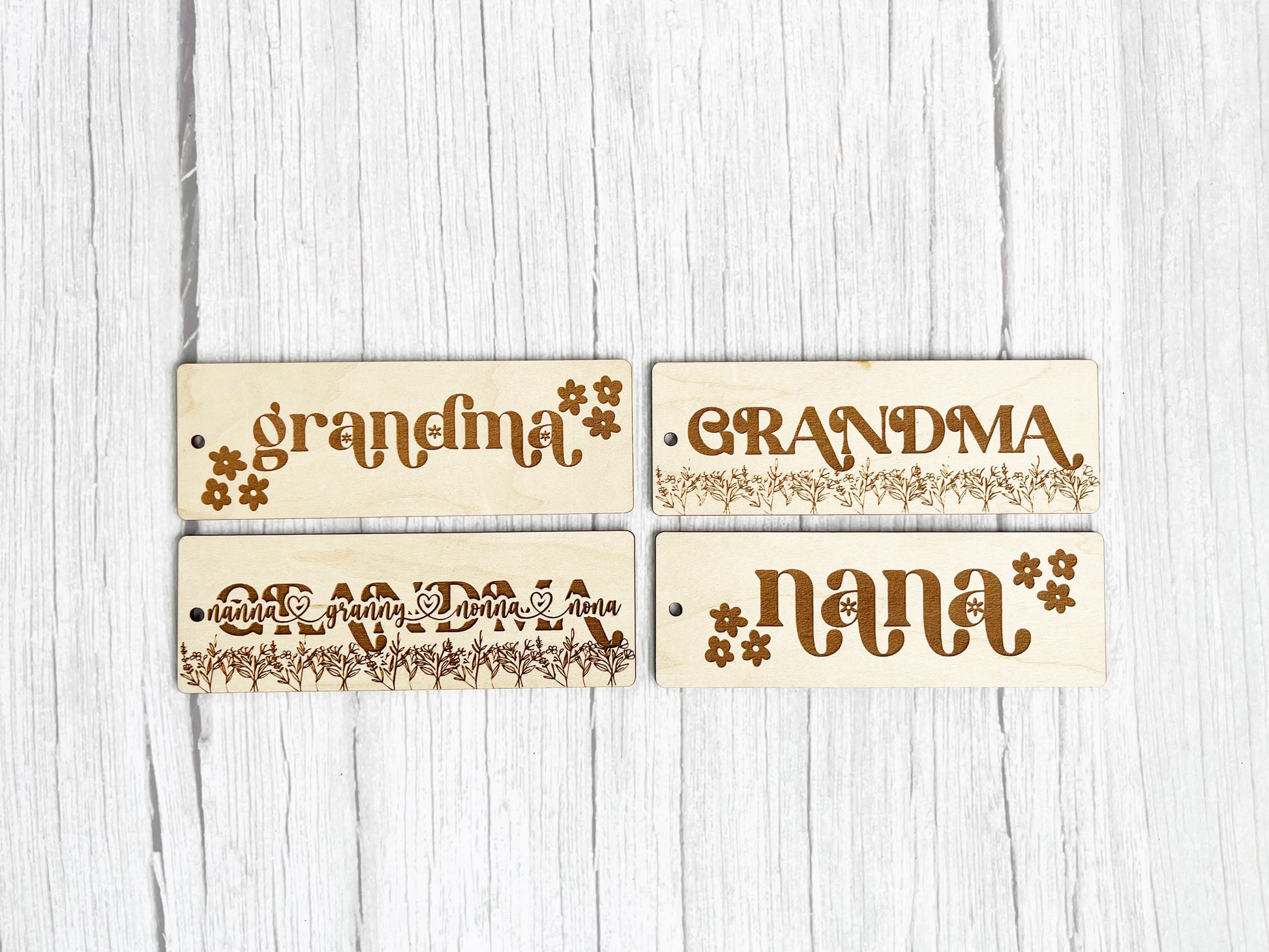 three wooden name tags on a white wooden surface