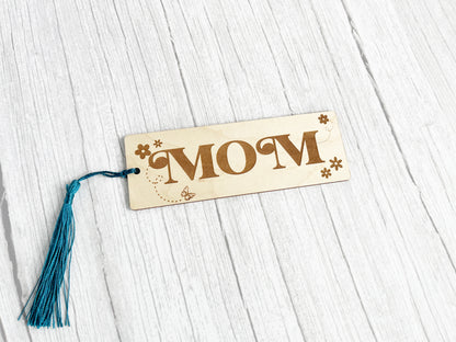 a wooden sign with a tassel hanging from it