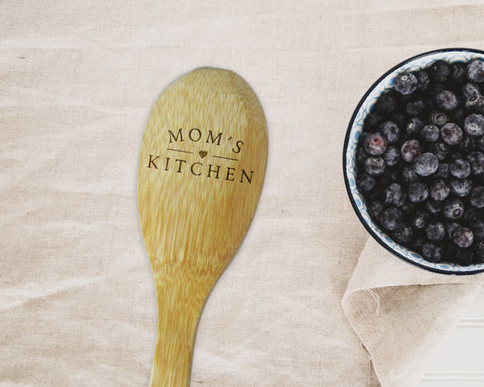 a wooden spoon next to a bowl of blueberries