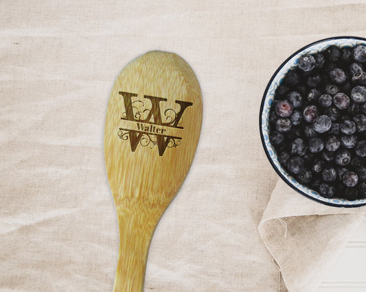 a bowl of blueberries next to a wooden spoon