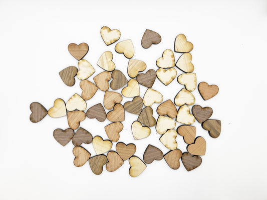 a pile of wooden hearts sitting on top of a white table