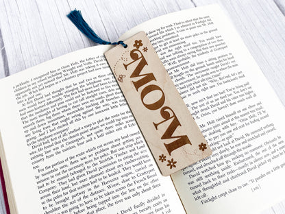 an open book with a bookmark that says mom on it