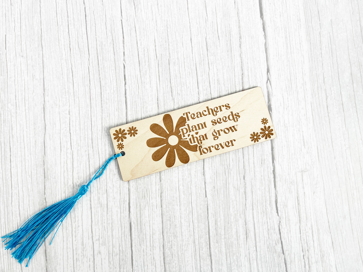 a wooden bookmark with a tassel hanging from it