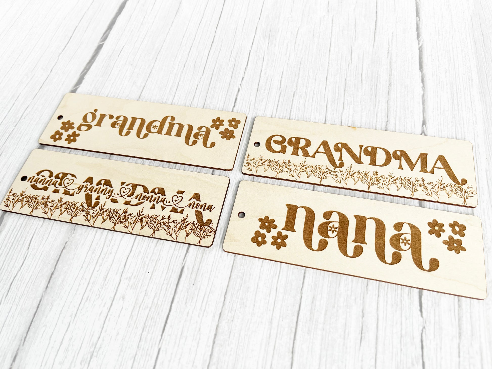 a set of four wooden name tags on a white table