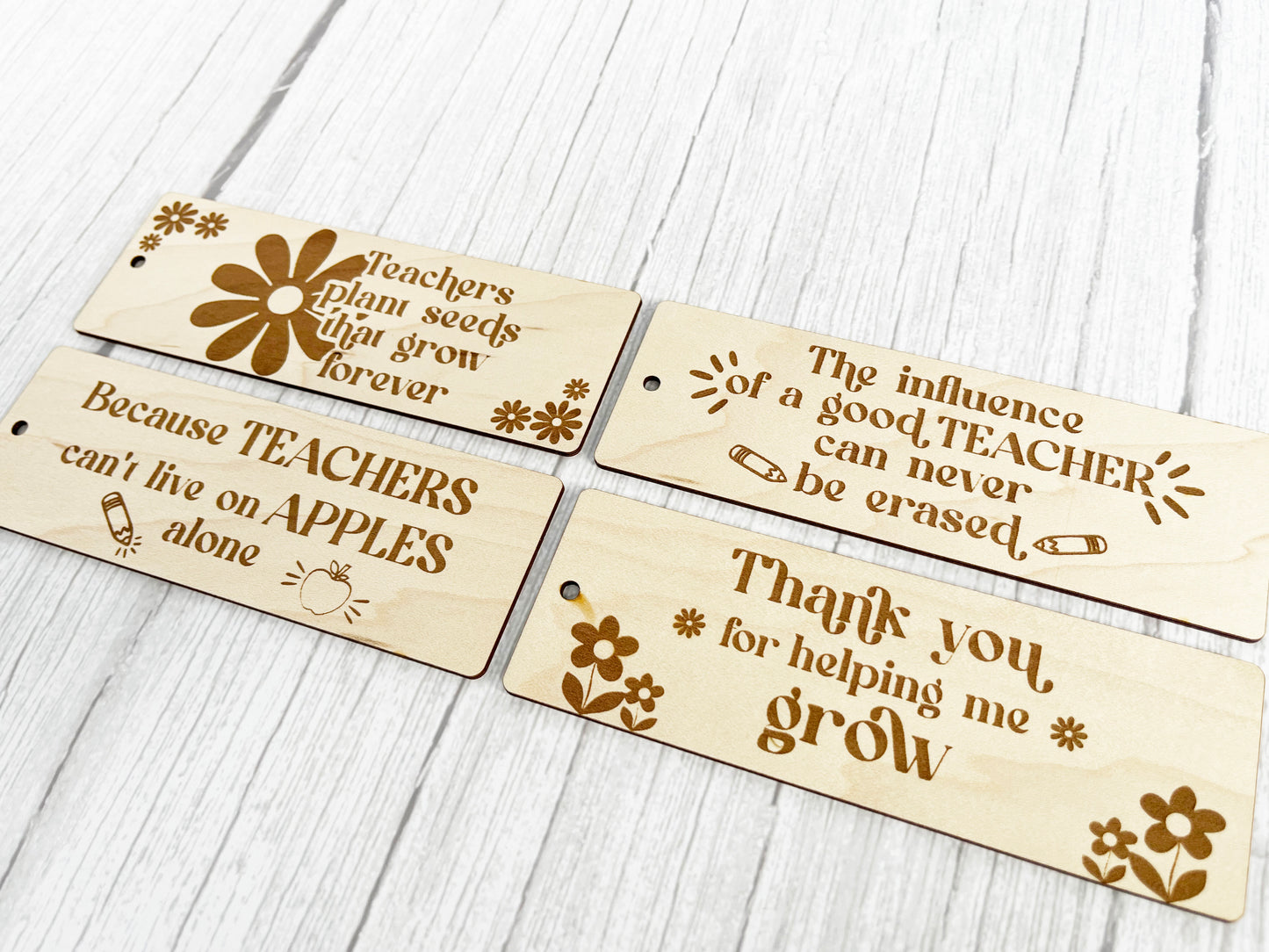 four wooden bookmarks with words on them