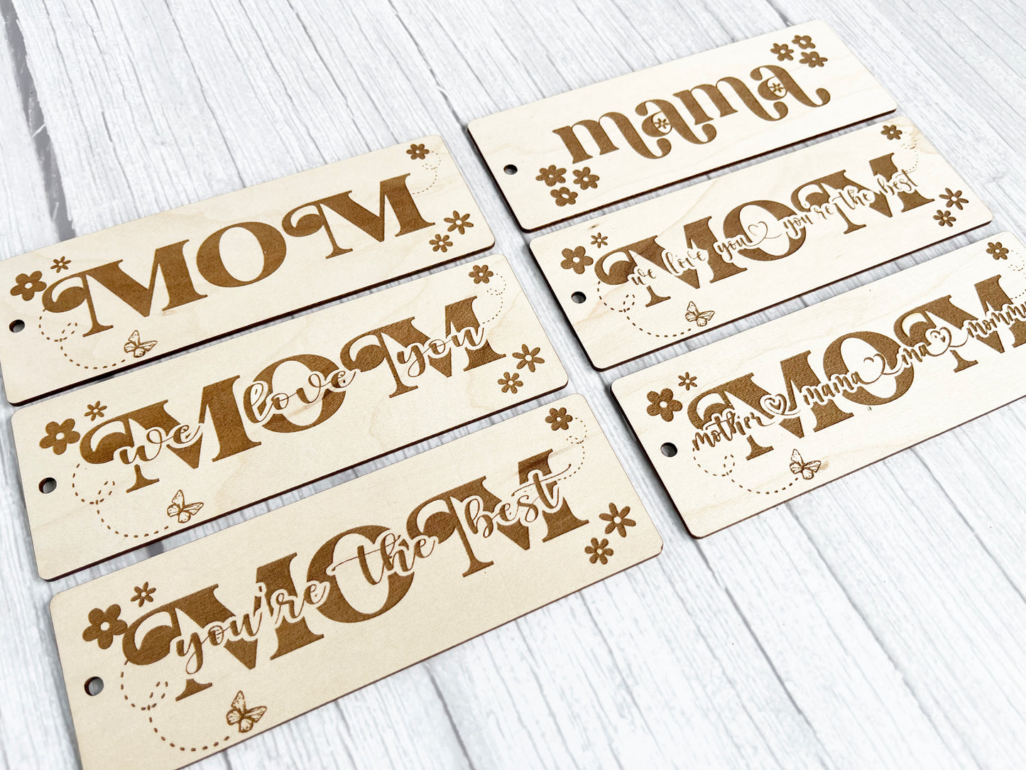 a set of four wooden name tags on a white table